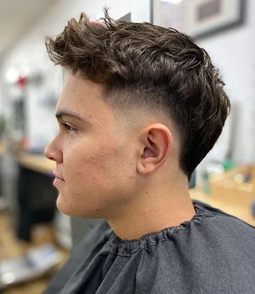 teen boy in a barber shop just had a Layered Mohawk with Fade hairstyle