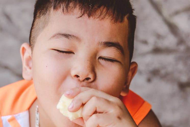 a boy enjoying eating with Miniature Mohawk hairstyle